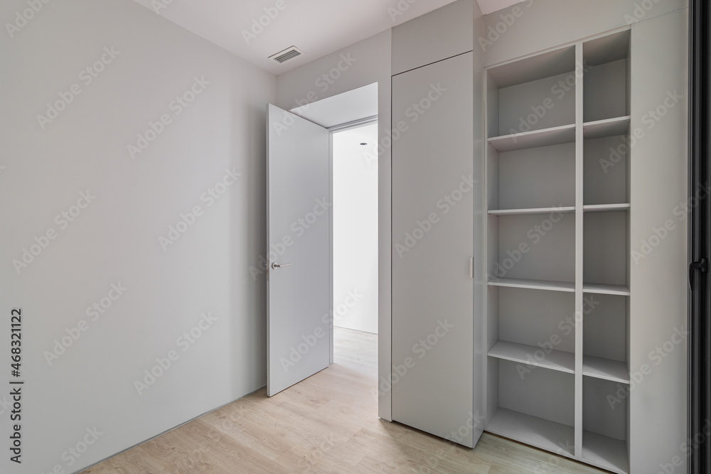 Interior of gray room with wardrobe and empty shelves. Refurbished apartment before settling of new tenants