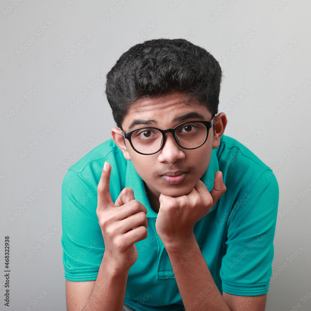Portrait of a boy of Indian ethnicity shows a warning gesture with finger