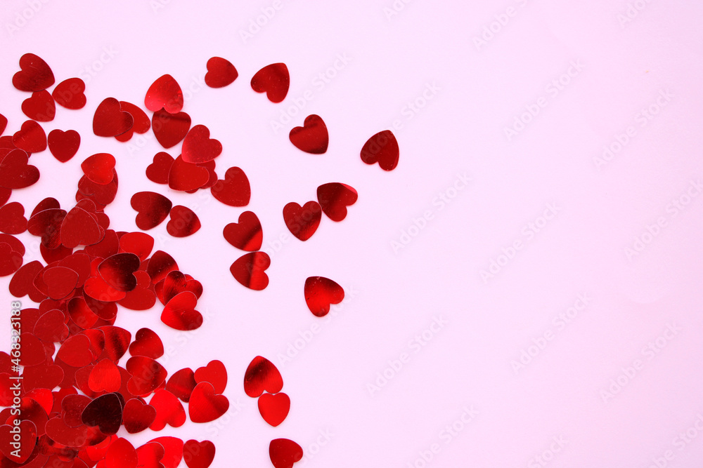 Red hearts shiny confetti on pink background, frame of hearts with space
