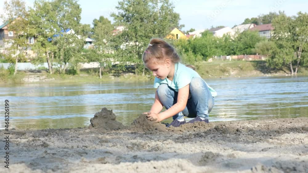 Child girl playing on the beach. Investigate details of nature. outdoor kids activity and learning concept Child girl playing on the beach. Investigate details of nature. outdoor kids activity and learning concept