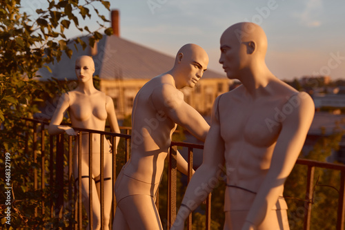 Nude mannequins of men and women standing on the roof and looking into the distance