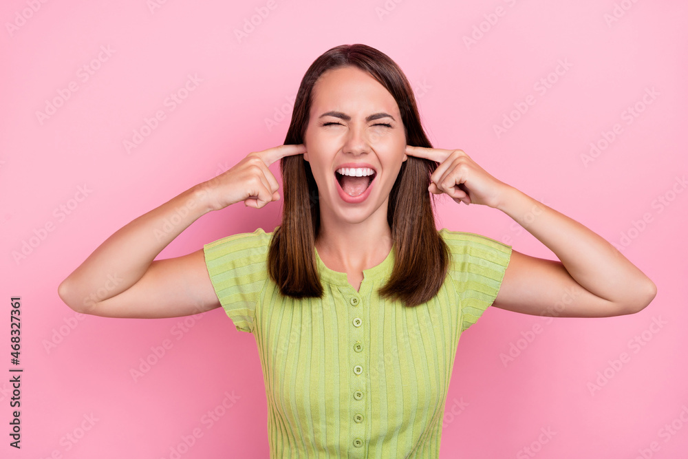 Fototapeta premium Photo of young girl cover ears fingers shout irritated mad crazy shirt top isolated over pink color background
