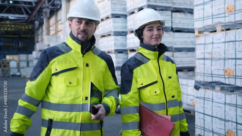 Follow footage of employees male and famale warehouse worker engineer in hard hat working. walking through logistics center warehouse factory construction site logistics architect businessman man