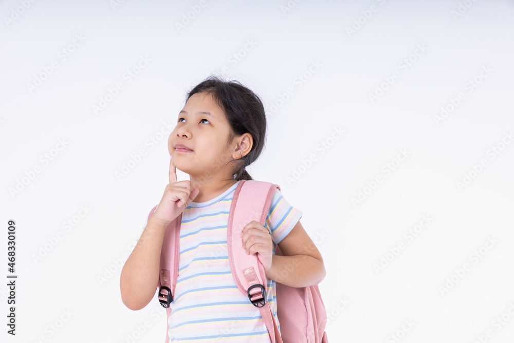 Back to school concept. Asian kids girl cute is standing thinking. Children with pink backpacks go to school on white background with copy space to get ready to study. Back to school concept. Asian kids girl cute is standing thinking. Children with pink backpacks go to school on white background with copy space to get ready to study.