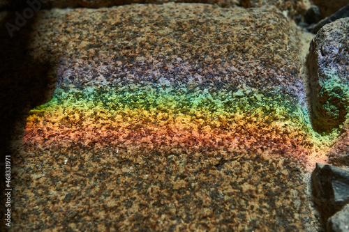 rainbow reflected on a granite wall from a ray of sunlight that came through a window selective focus