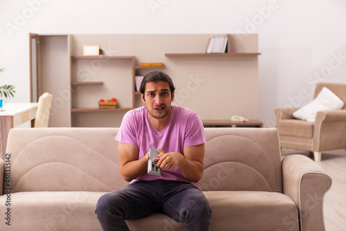 Young man watching tv at home during pandemic © Elnur