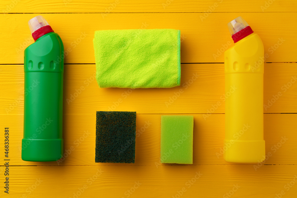 Cleaning tools composition flat lay on yellow wooden background
