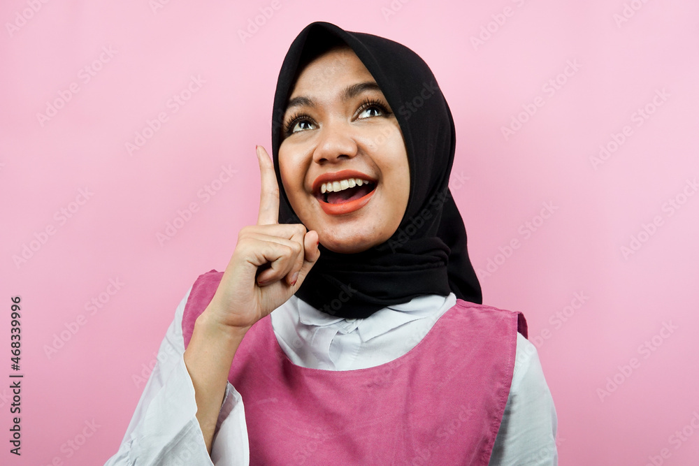 Closeup of beautiful young Muslim woman pointing up isolated Closeup of beautiful young Muslim woman pointing up isolated