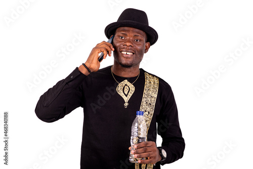 young man talking on mobile phone and holding bottle of mineral water.