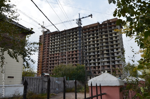 A building under construction with two cranes