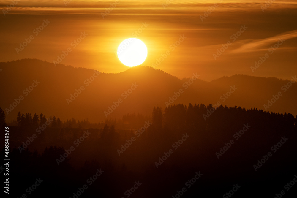 Big sun and silhouette of mountains