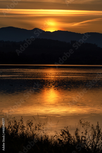 Sunset over mountains. Reflection on water surface. Colorful twilight sky photo