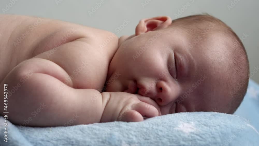 infancy, childhood, development, medicine and health, love, care concept - close-up face of newborn naked sleeping little small infant baby boy lying on stomach on soft blue banket on bed at home infancy, childhood, development, medicine and health, love, care concept - close-up face of newborn naked sleeping little small infant baby boy lying on stomach on soft blue banket on bed at home