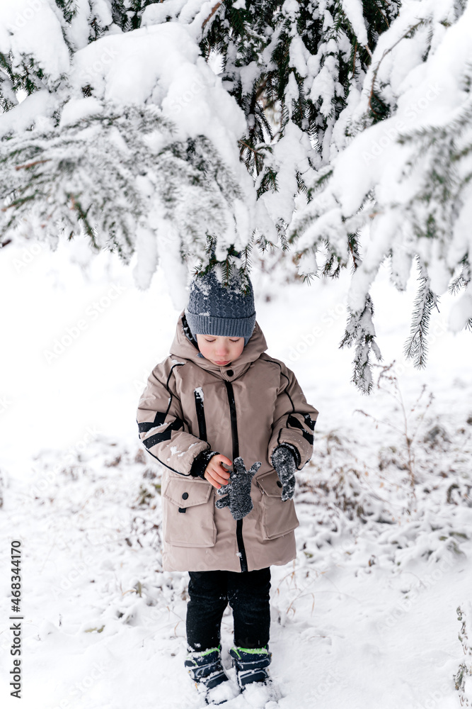 boy under the tree in the snow