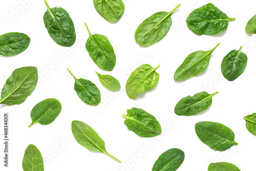 Pattern of fresh spinach leaves with drops on a white background. Top view, flat lay.