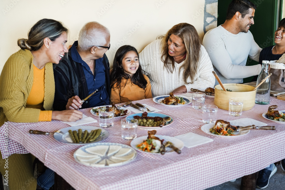 Happy latin family having fun eating together at home- Focus on grandmother face