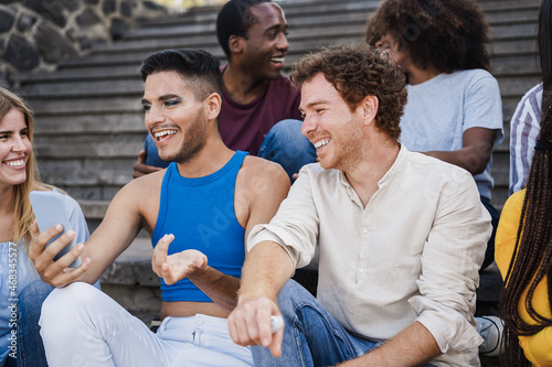 Young diverse people having fun outdoor laughing together - Focus on right man face