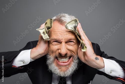 Εκτύπωση καμβά insane middle aged businessman holding dollar banknotes and grinning isolated on