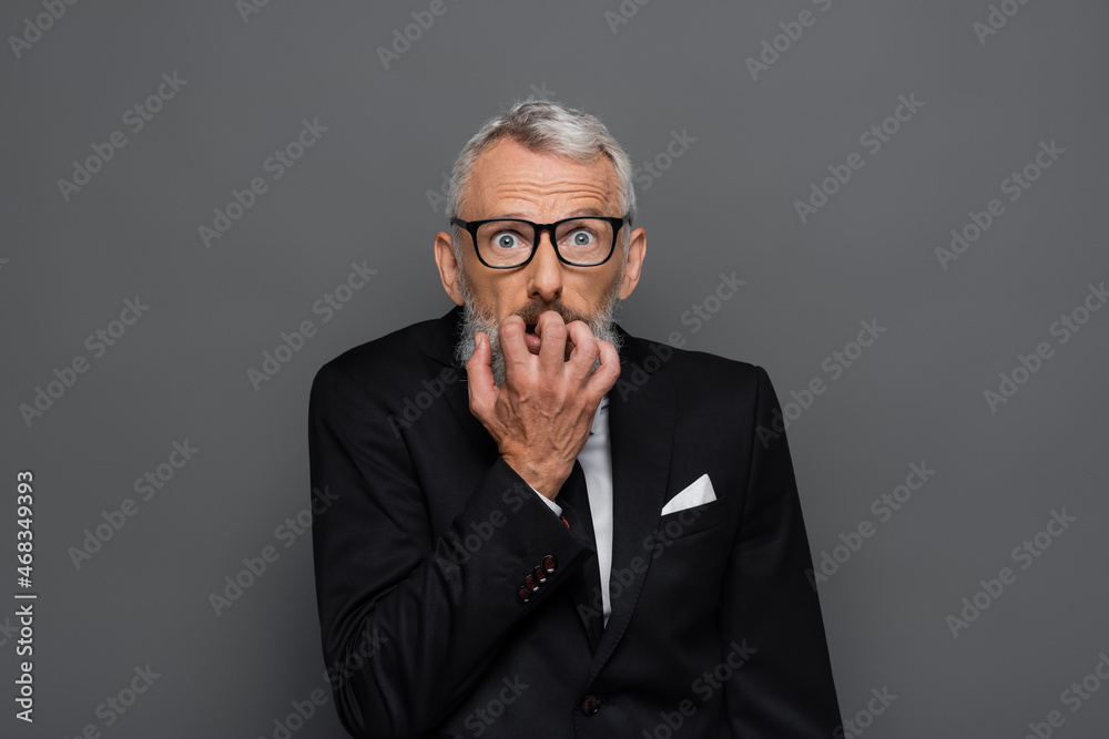 scared middle aged businessman in glasses gesturing isolated on grey scared middle aged businessman in glasses gesturing isolated on grey