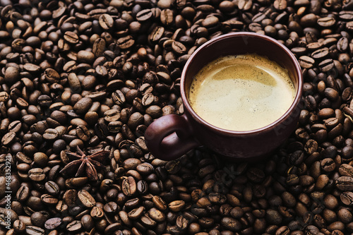 Coffee cup with free space for text on roasted coffee beans close up