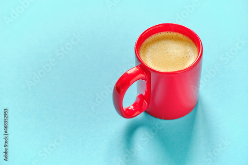 Red coffee cup on blue background with free space for text
