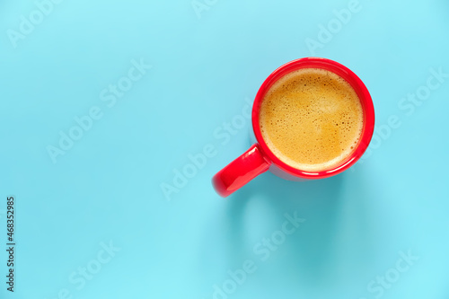 Red coffee cup on blue background with free space for text. Top view