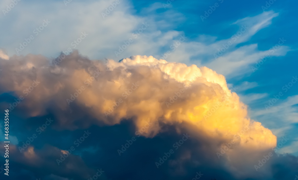 Pre-storm sky with cumulus clouds illuminated by the rays of the setting sun in summer Pre-storm sky with cumulus clouds illuminated by the rays of the setting sun in summer