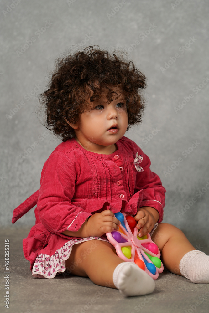 Fototapeta premium Portrait of a baby girl in a red dress.