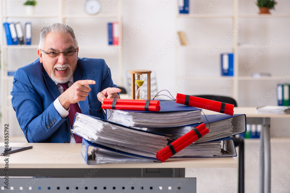 Old male employee with dynamite in the office Old male employee with dynamite in the office