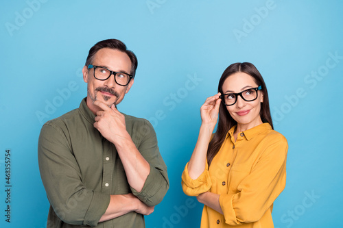 Photo of minded pretty lady handsome man look interested empty space isolated on blue color background photo