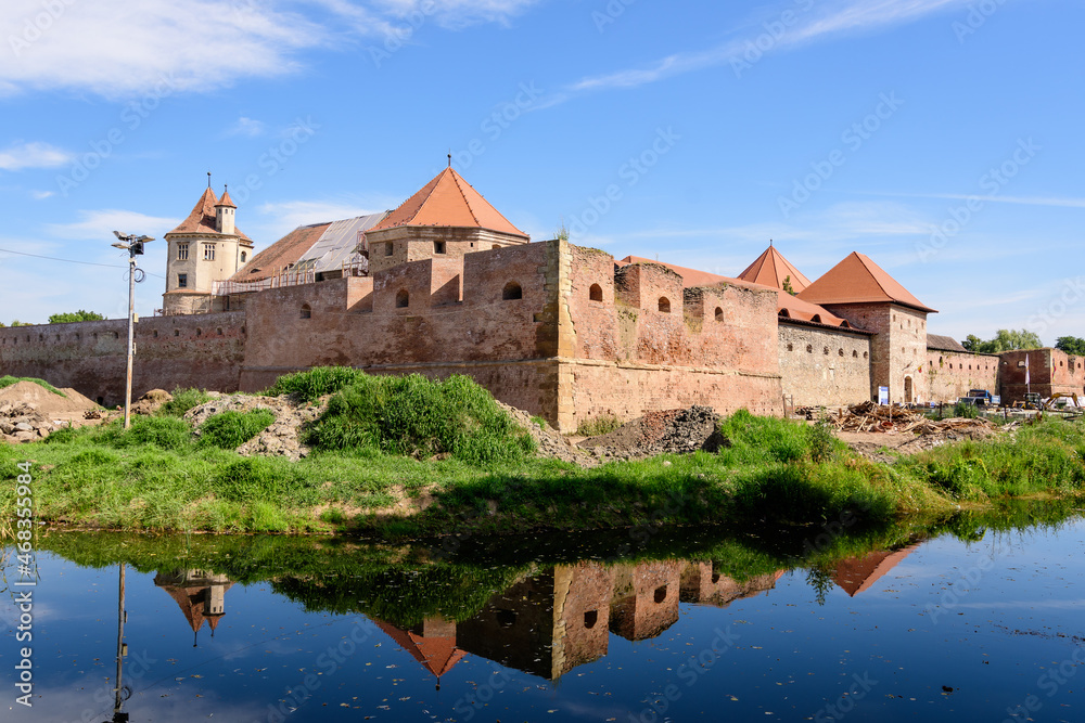 Renovated old historical buildings  of Fagaras Fortress (Cetatea Fagaras) during renovation works in a sunny summer day, in Transylvania (Transilvania) region, Romania  .