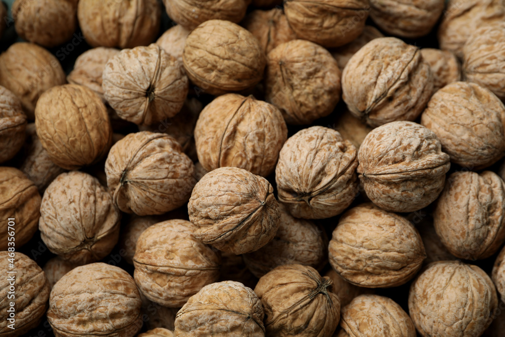 Walnuts in nutshell all over background, top view Walnuts in nutshell all over background, top view