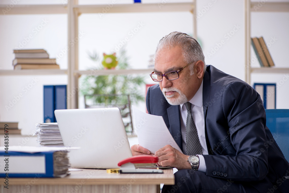 Old male employee and too much work in the office Old male employee and too much work in the office