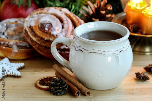 A ceramic mug with tea among traditional Christmas decorations.