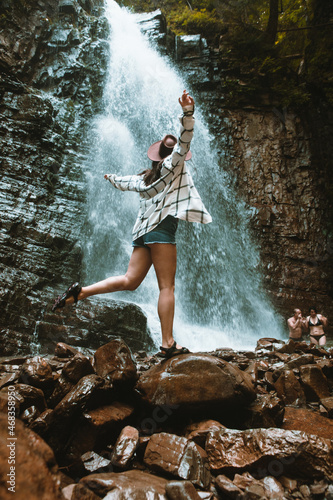 woman in brown hat enjoying view of waterfall