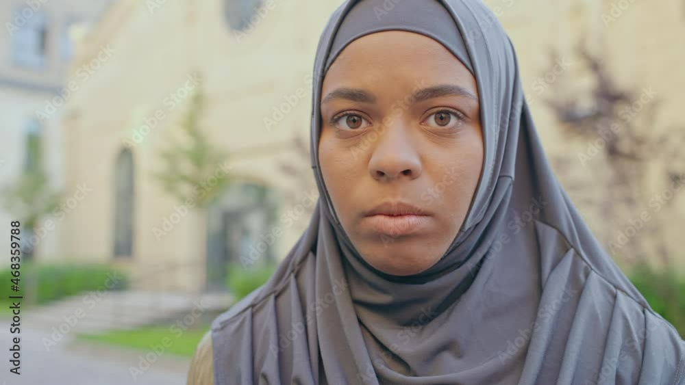 Black muslim female in hijab looking at camera, women's rights, islamic culture Black muslim female in hijab looking at camera, women's rights, islamic culture