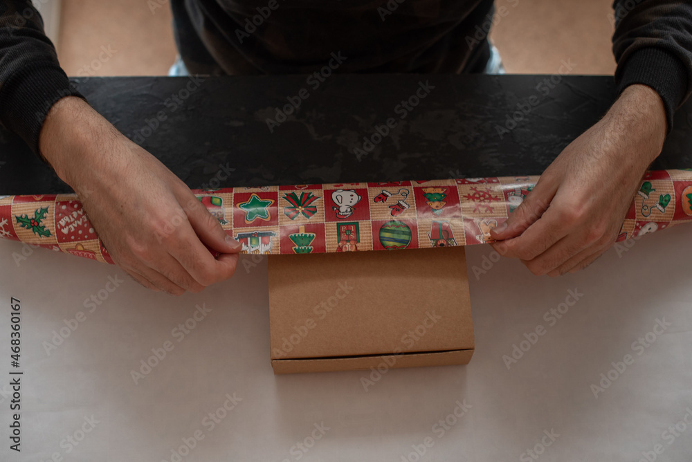 Obraz premium A man is packing a gift