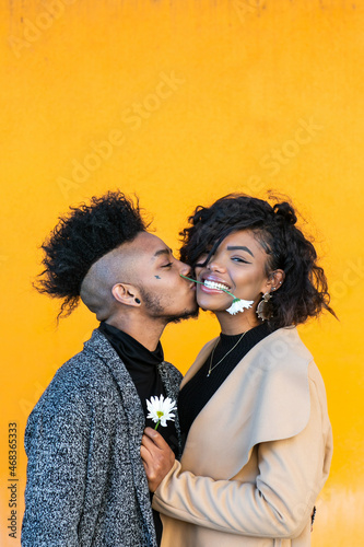 Konstfotografi African American transgender couple smiling, with flower in her mouth, hanging o