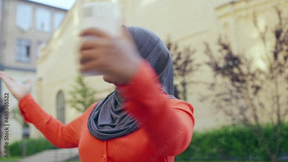 Excited muslim woman talking to family online by smartphone app, internet Excited muslim woman talking to family online by smartphone app, internet