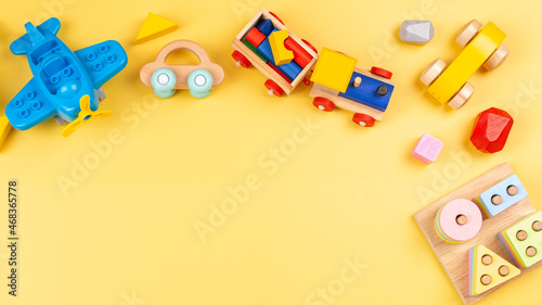Baby kids toy for children. Educational wooden and plastic toys on yellow background. Top view, flat lay