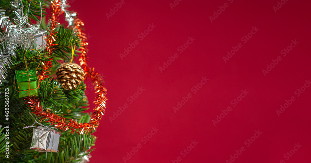Part of Christmas tree over a red background with copy space for text