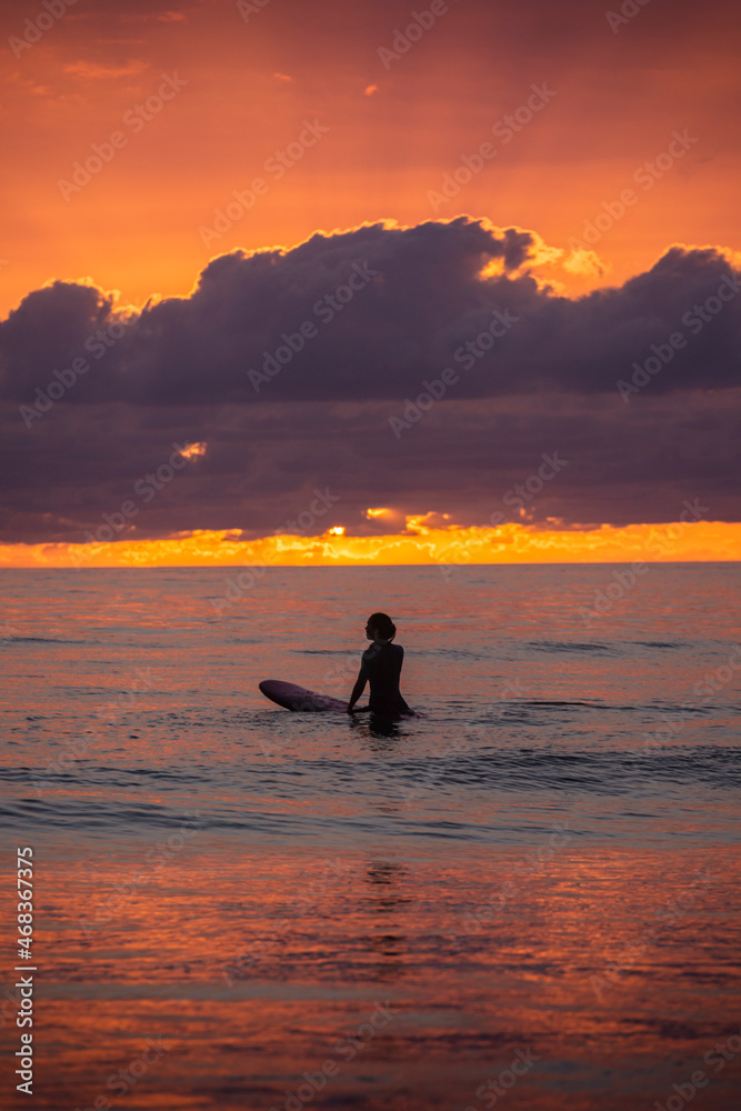 Chica joven surfista al atardecer en la playa de El Palmar, Cádiz, Andalucía, España