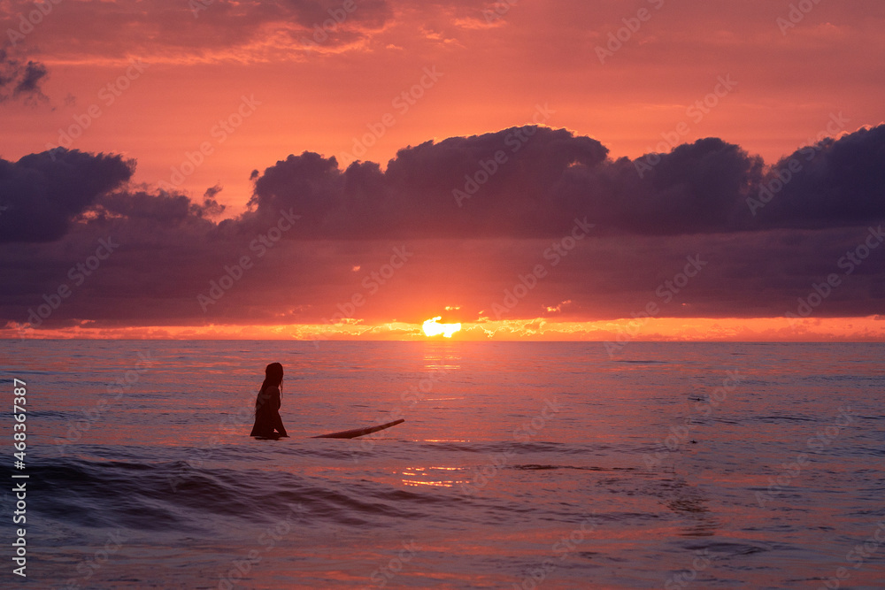 Chica joven surfista al atardecer en la playa de El Palmar, Cádiz, Andalucía, España