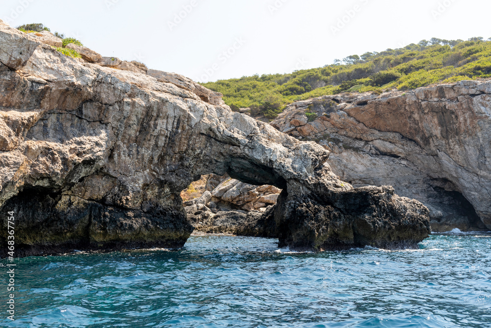 Natural arch in the limestone rock of the coast of the island of San Domino of the archipelago of the Tremiti Islands