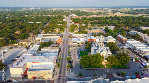 Top view historic Hood County Courthouse and Clock Tower and lush green neighborhood in Granbury, Texas, USA