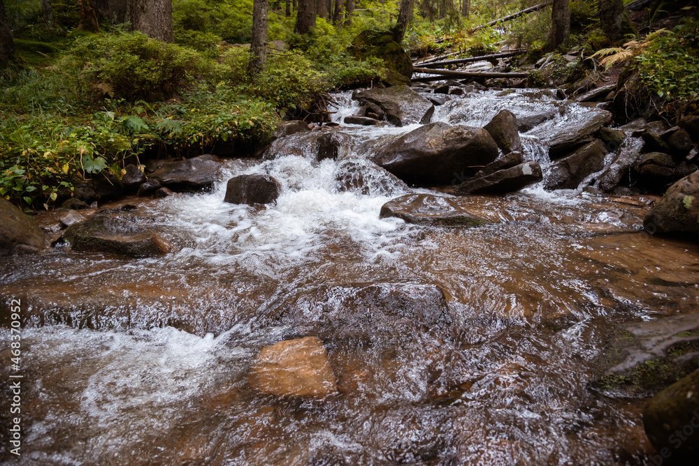 Beautiful landscape of a waterfall in the forest with water and stones in the foreground Beautiful landscape of a waterfall in the forest with water and stones in the foreground