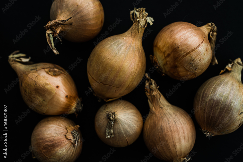 Raw yellow onion on the black background, Onion flat lay, vegetarian fresh, close up photo Raw yellow onion on the black background, Onion flat lay, vegetarian fresh, close up photo