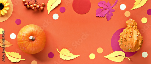 Decorative Fall flat lay, top view on orange paper background with hokkaido pumpkins, confetti and Autumn paper leaves.