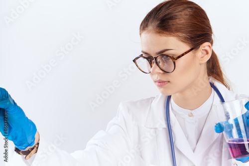 female doctor sitting at the table with blue gloves medication tests