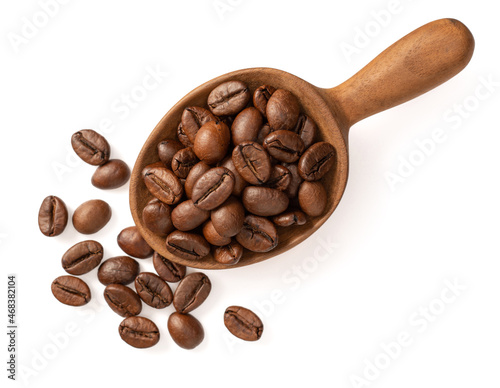 Coffee beans in the wooden spoon, isolated on white background, top view